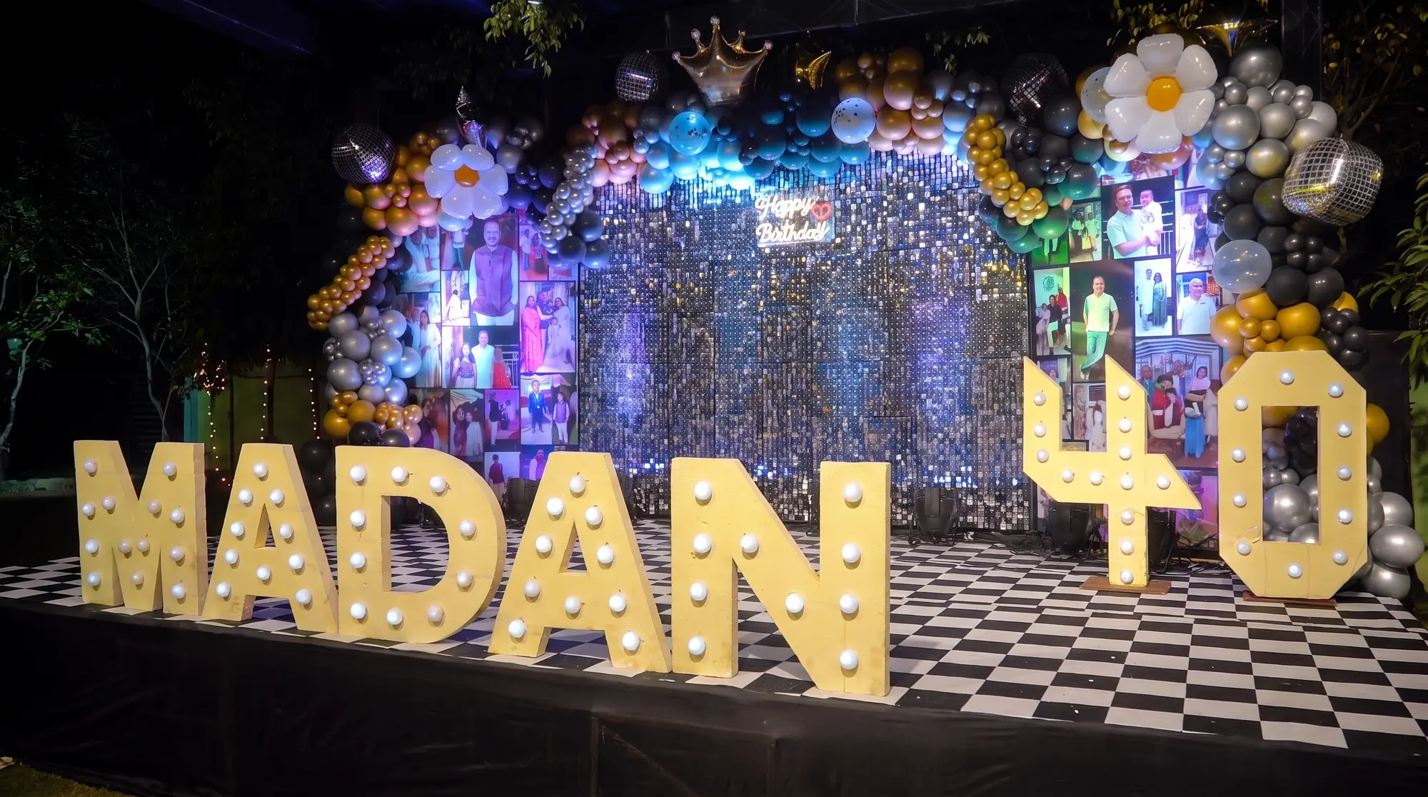 Illuminated marquee letters spelling the guest of honour's name beside a giant 40, in front of a sequin photo wall with a balloon garland, disco balls and a chequerboard dance floor at a 40th birthday at Elysian Lawn, Salt Lake, Kolkata
